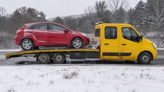 Czerwone auto na lawecie zimą – wymiana koła Gniezno